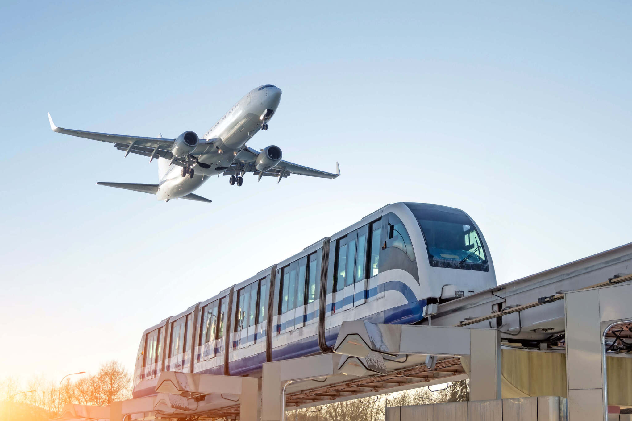Ein Flugzeug, das über einem Zug hinwegfliegt.