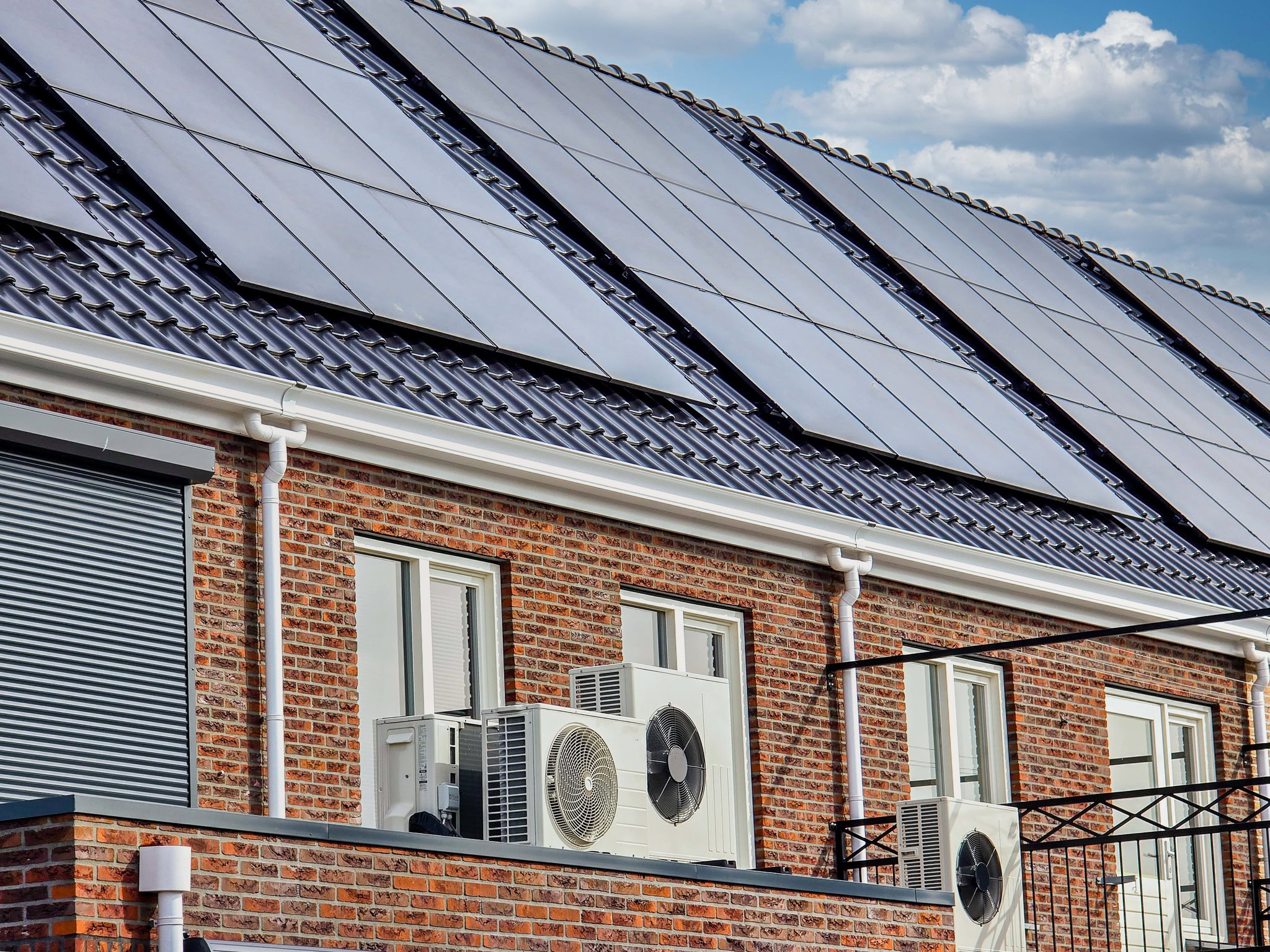 Reihenhaus mit Solaranlage auf dem Dach und Wärmepumpen, um GEG-Anforderungen zu entsprechen.