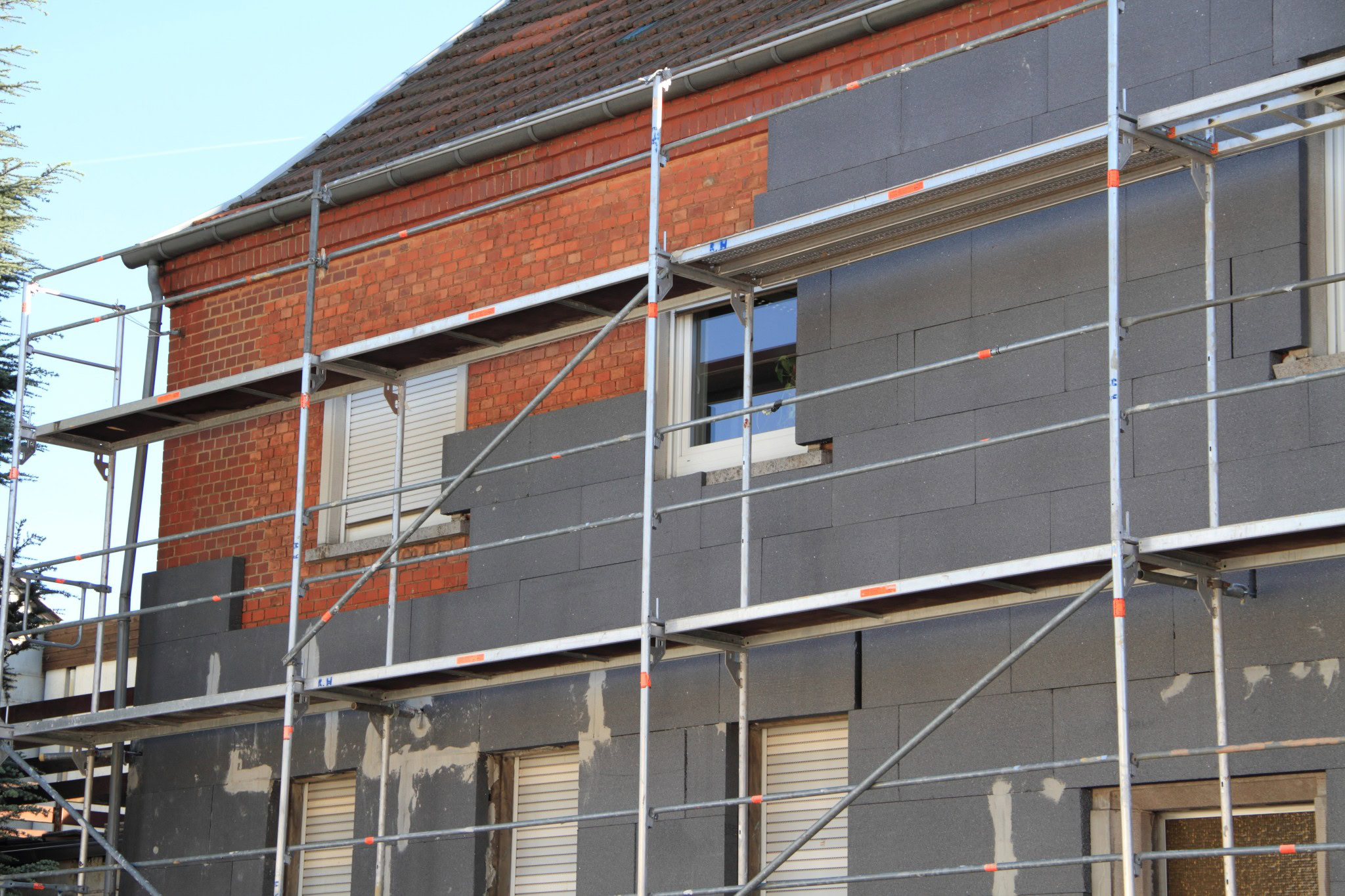 Dämmarbeiten an der Fassade eines Bestandsgebäudes zur Umsetzung der GEG-Pflichten.