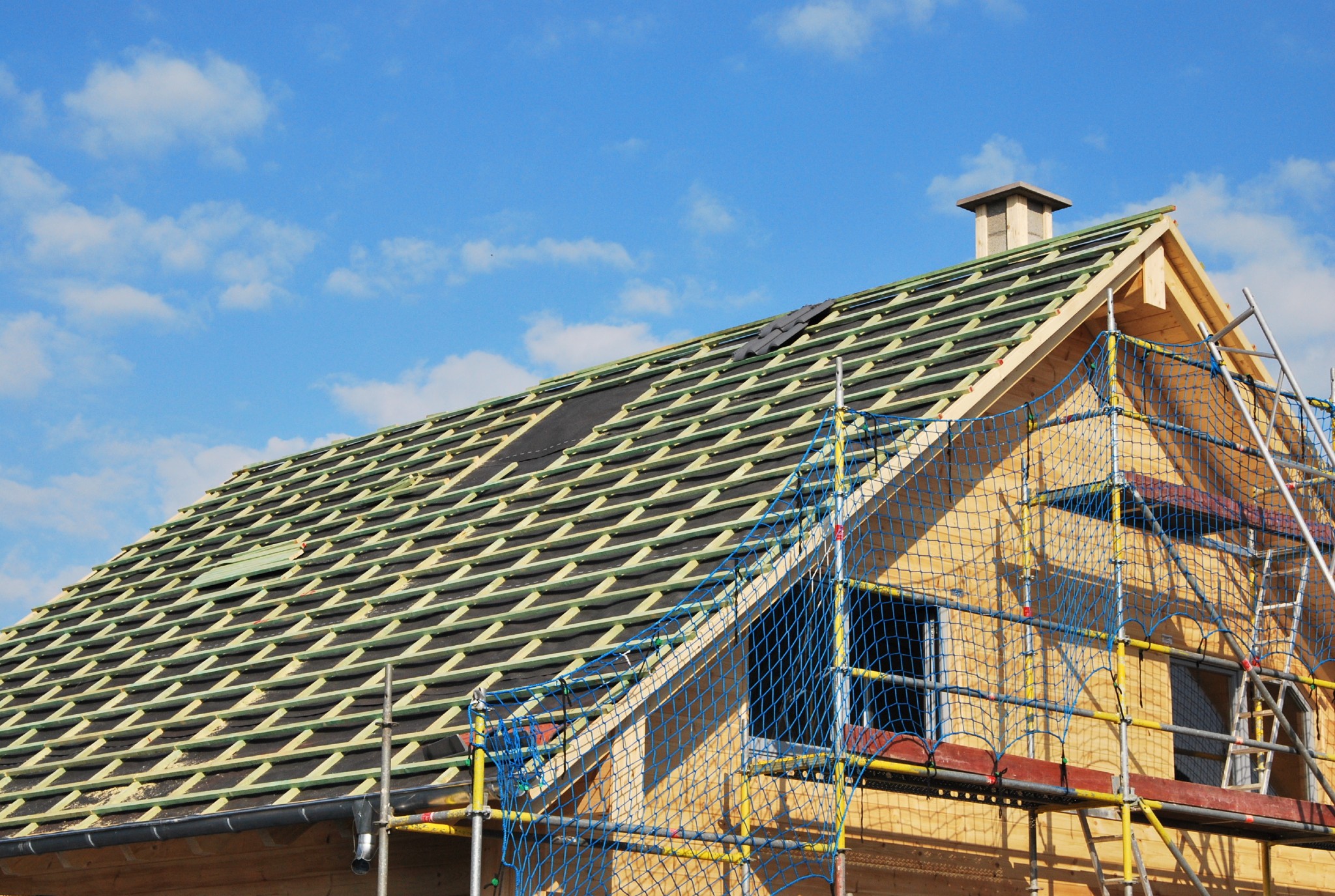 Hausdach in Sanierung mit sichtbarer Dachlattung und Baugerüst – Vorbereitung für Dachdämmung gemäß Gebäudeenergiegesetz (GEG)