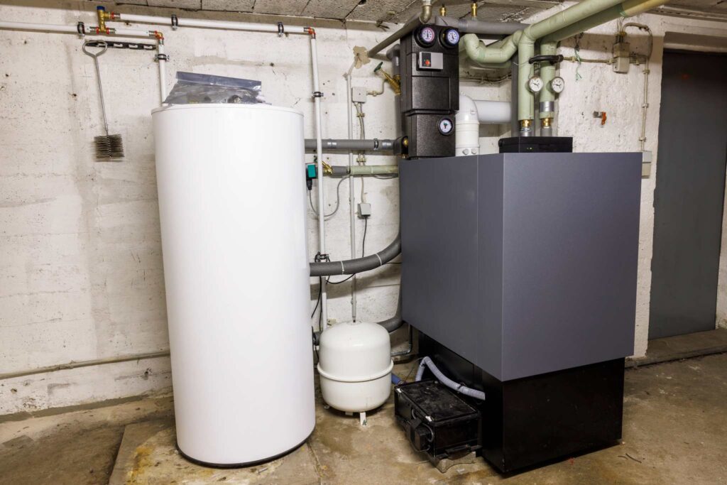 Ölheizung mit Warmwasserspeicher und Rohrleitungen in einem Heizungskeller.